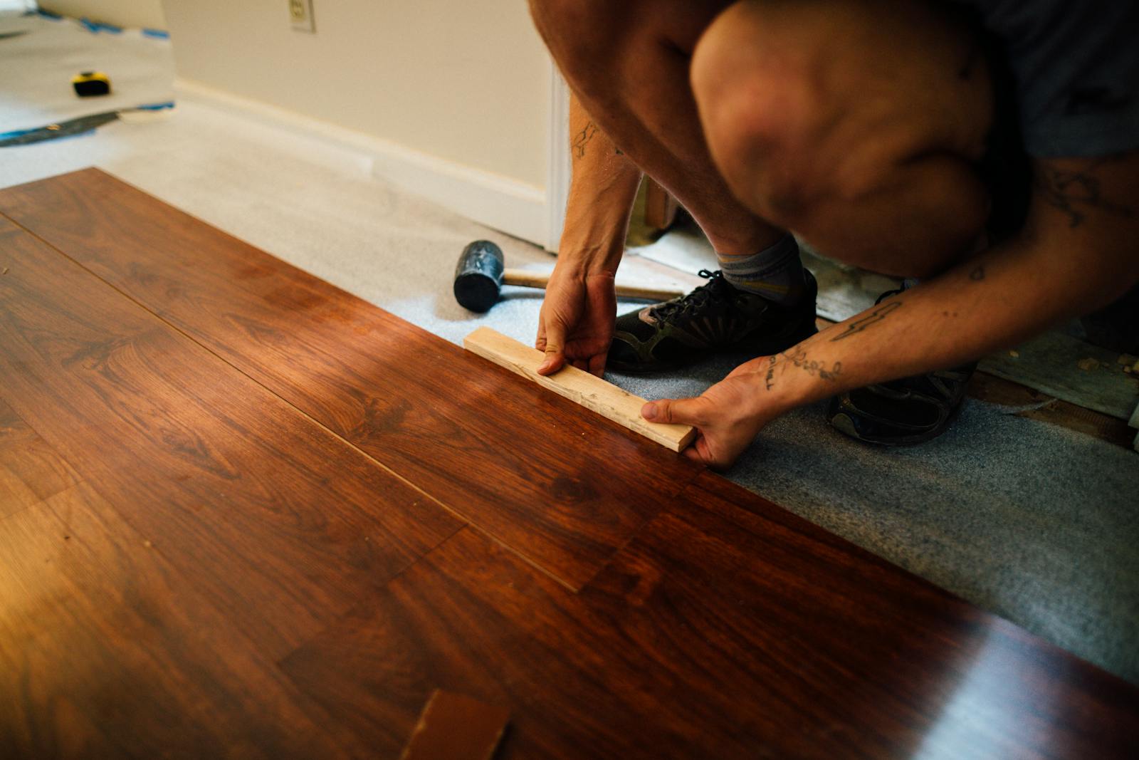 Professional installing hardwood floor planks